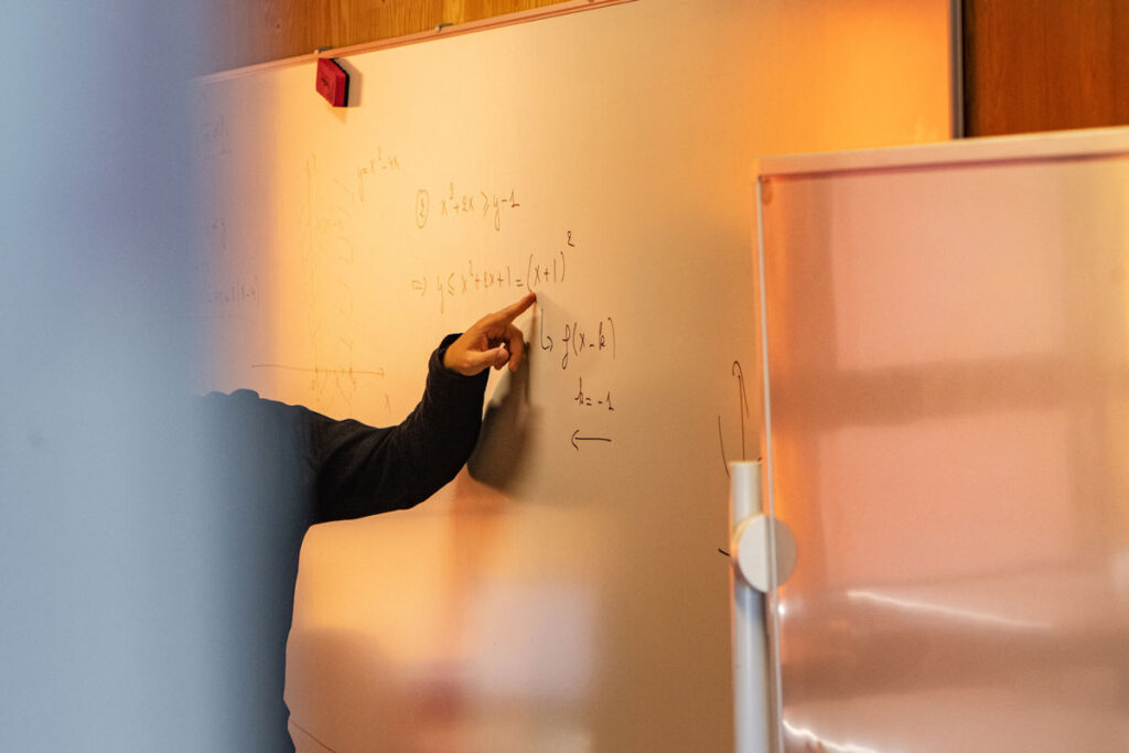 Leerkracht die notities aanduidt op het schoolbord