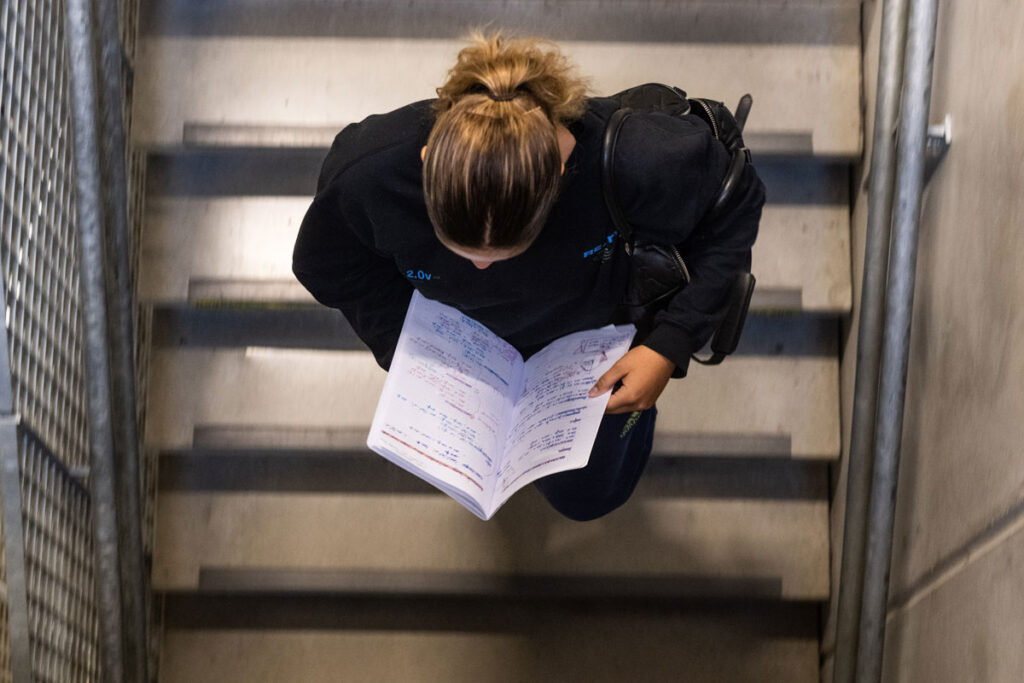 Student die de trappen afdaalt terwijl ze in een boek aan het kijken is