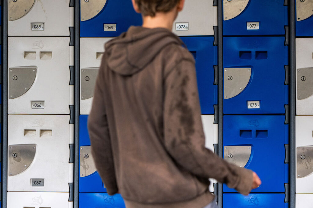 Jongen die voor de lockers staat op de speelplaats