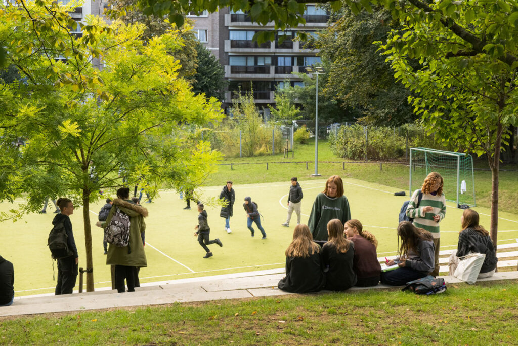 kinderen die aan het voetballen zijn op een voetbalpleintje